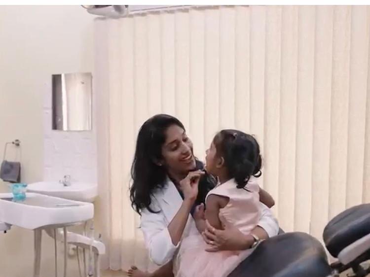 A child sitting with Dr Lalitya in the dental chair